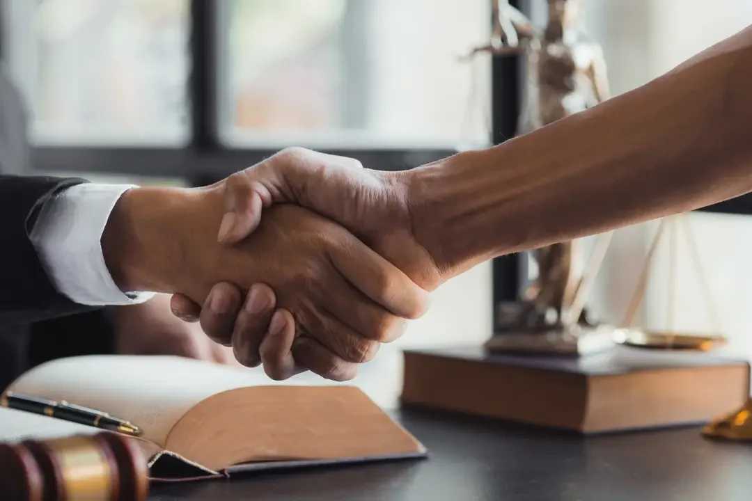 client shaking hands with a meso lawyer after winning a case