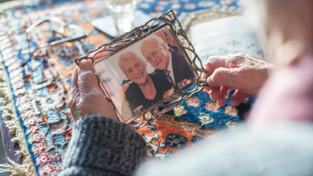 grieving woman holding a framed photo of a loved one