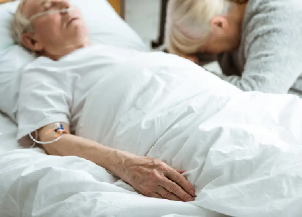 elderly woman with a sad expression sitting beside her husband