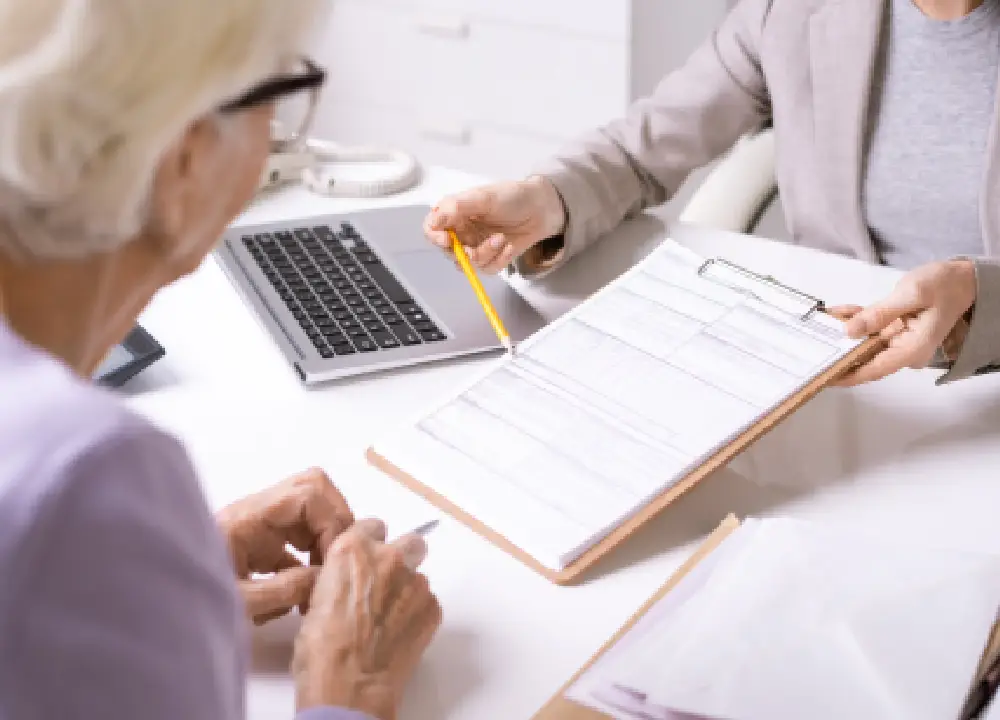 elderly woman sitting with a lawyer, reviewing documents