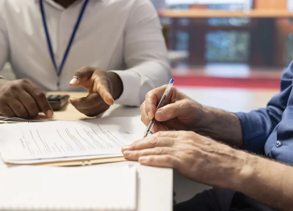 elderly man signing a legal document