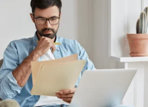 “Man looking seriously at laptop screen, focused and thoughtful.