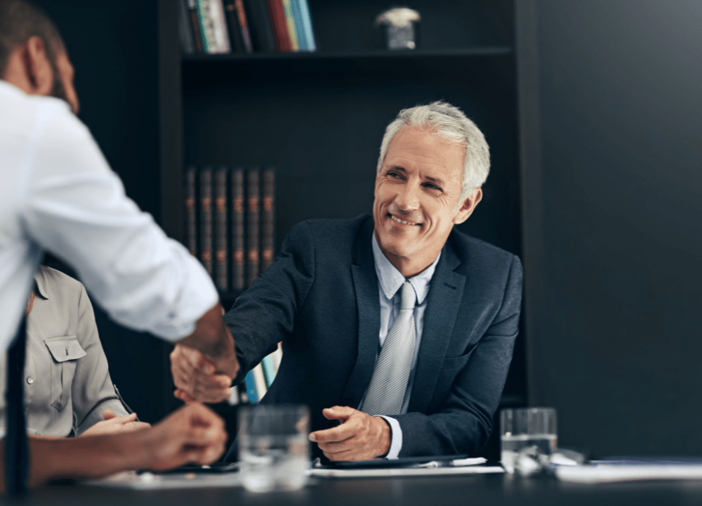 Mesothelioma lawyer shaking hands with family pursuing asbestos wrongful death claim.